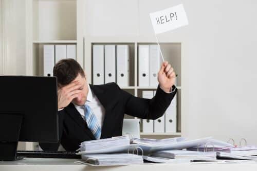 Overworked Accountant Holding Help Sign While Working